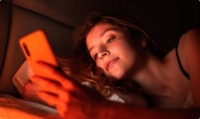 woman using her phone to manage multiple eSIM profiles for seamless IoT connectivity, showcasing the ease of global communication and device management.